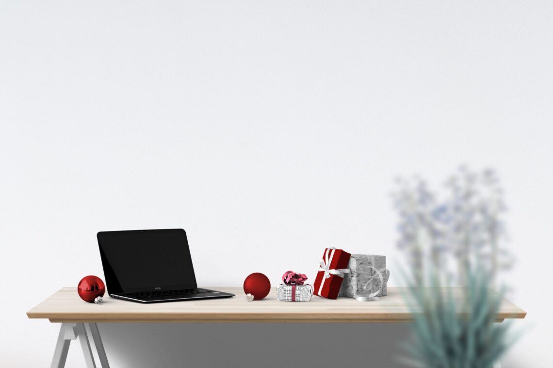 Laptop neben Weihnachtsdeko – Winterpause mit Abwesenheitsnotiz zu Weihnachten